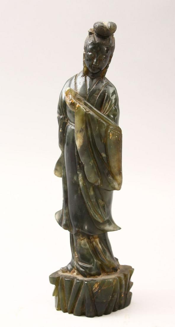 A 20TH CENTURY CHINESE CARVED JADE FIGURE OF GUANYIN,: A 20TH CENTURY CHINESE CARVED JADE FIGURE OF GUANYIN, stood upon a stylized stump base holding a Ruyi-sceptre, 24cm high.