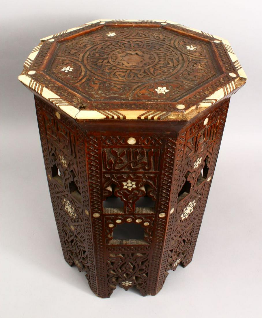 A SMALL 19TH CENTURY INDIAN HARDWOOD OCTAGONAL: A SMALL 19TH CENTURY INDIAN HARDWOOD OCTAGONAL TRAVELLING OCCASIONAL TABLE, the table inlaid with carved bone floral decoration, the top removes, base folds, 32cm high x 31cm wide.