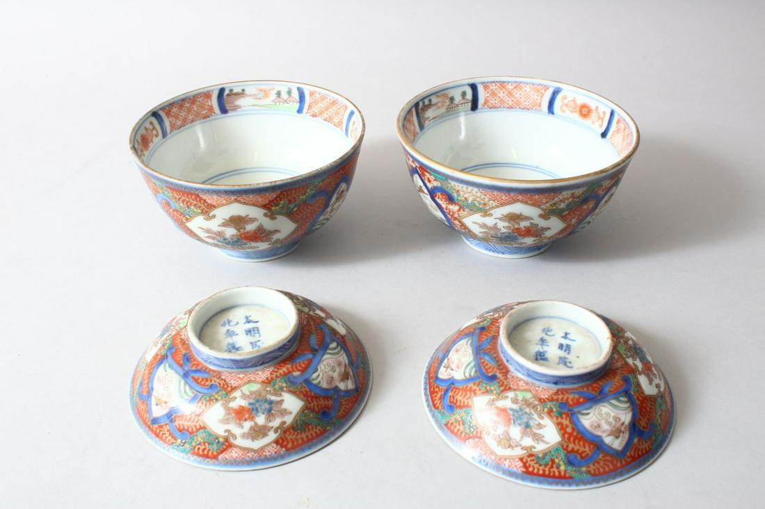 A PAIR OF JAPANESE MEIJI PERIOD IMARI PORCELAIN BOWLS: A PAIR OF JAPANESE MEIJI PERIOD IMARI PORCELAIN BOWLS AND COVERS, painted with alternating panels of flowers and birds, mark to the base, bowls 12.5cm diameter.