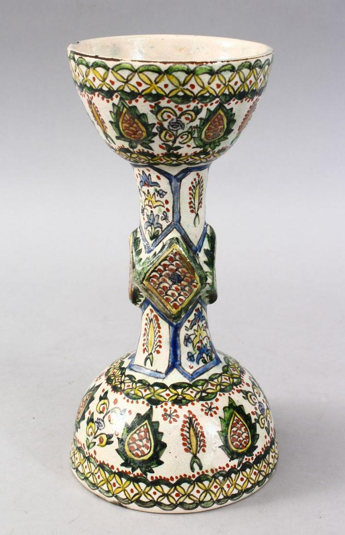 A GOOD EARLY ISLAMIC TURKISH POTTERY STEM CUP, the body: A GOOD EARLY ISLAMIC TURKISH POTTERY STEM CUP, the body of the vessel decorated with panels of floral display, the base bearing an artist mark, 24cm high.