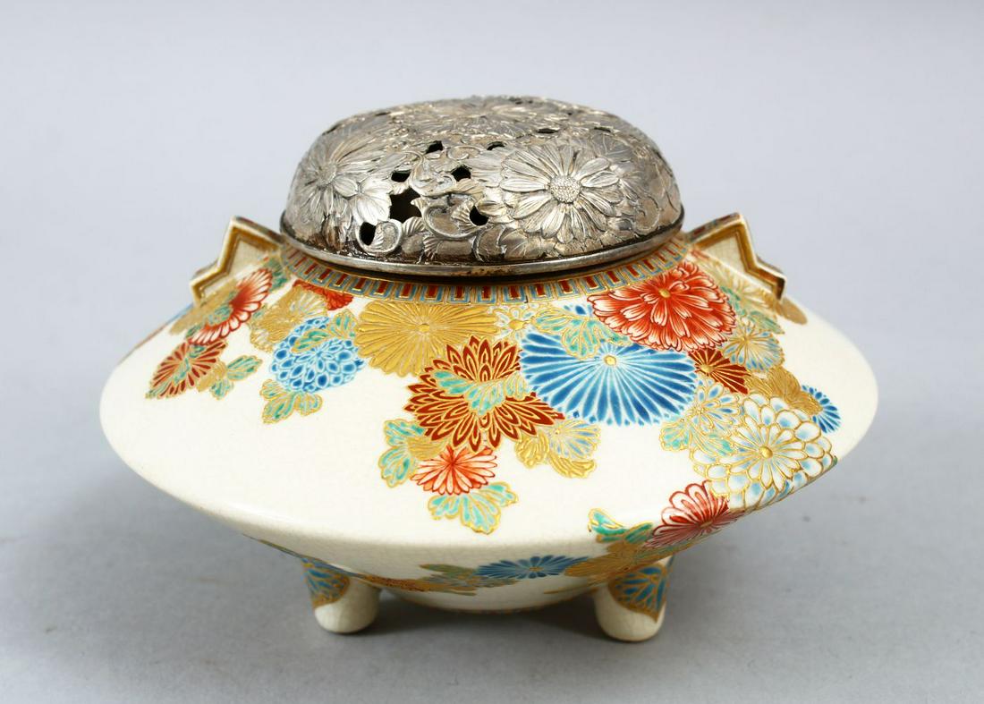 A JAPANESE MEIJI PERIOD SATSUMA LIDDED KORO, finely: A JAPANESE MEIJI PERIOD SATSUMA LIDDED KORO, finely decorated with native floral decoration, twin moulded handles, tripod moulded feet, chrysanthemum pierced white metal cover, 8cm high x 13cm diamete
