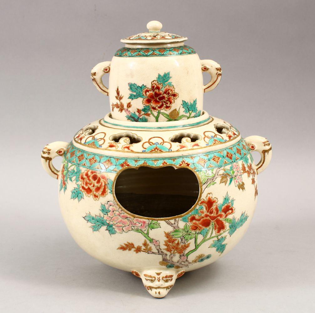 A JAPANESE MEIJI PERIOD SATSUMA THREE SECTION HIBATCHI,: A JAPANESE MEIJI PERIOD SATSUMA THREE SECTION HIBATCHI, the globular vessel housing a smaller vase and cover, with elephant mask handles, seated upon three Oni mask feet, the body decorated with peony