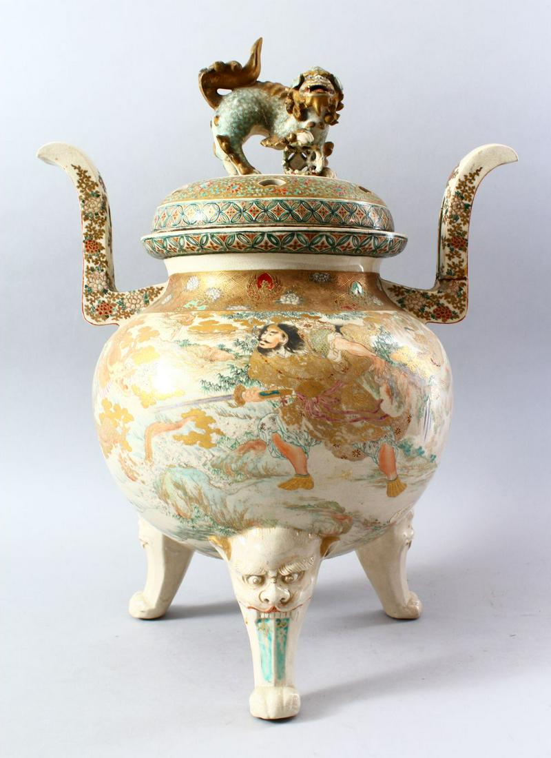 A LARGE JAPANESE MEIJI PERIOD TIRIPOD KORO & COVER, the: A LARGE JAPANESE MEIJI PERIOD TIRIPOD KORO & COVER, the body with twin raised handles decorated with floral borders, the body decorated with a warrior and figures in a landscape setting, between flora