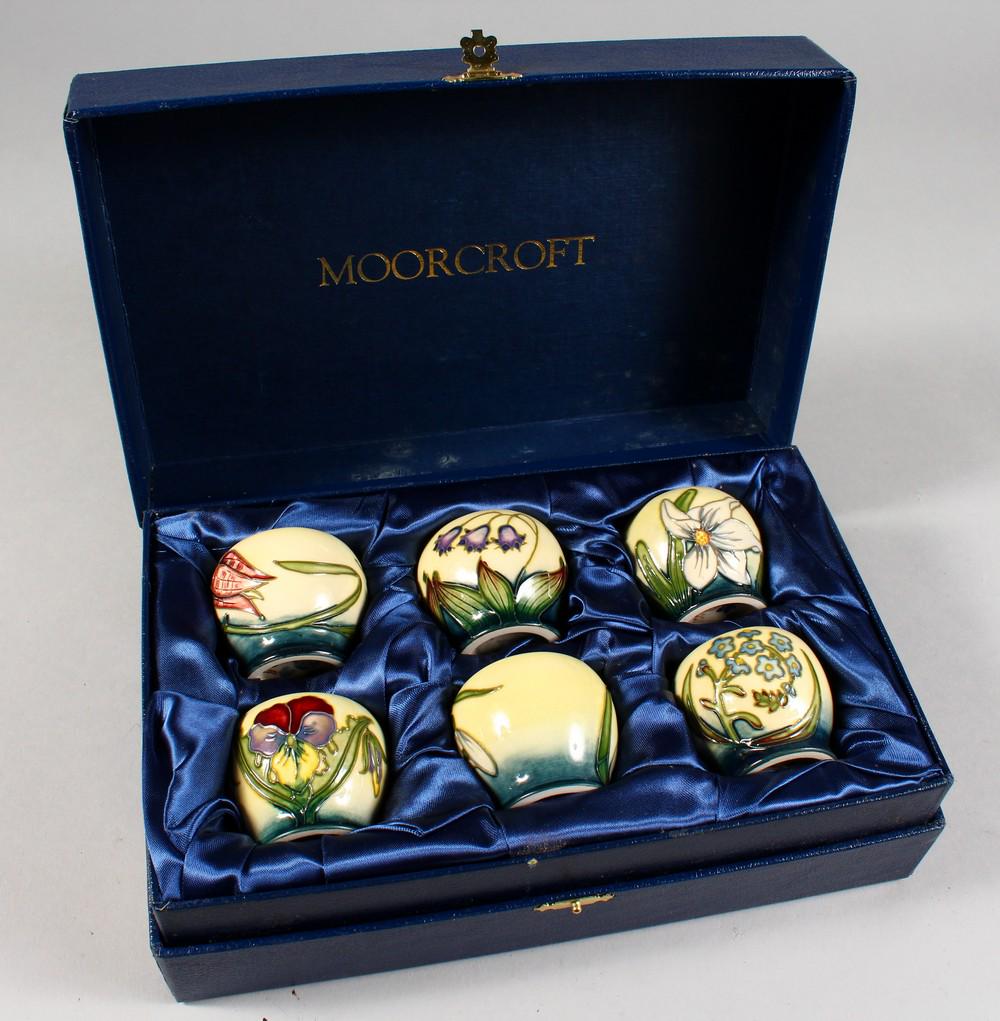 A SET OF SIX W. MOORCROFT EGG CUPS 2001, 1.75ins high,: A SET OF SIX W. MOORCROFT EGG CUPS 2001, 1.75ins high, in a fitted Moorcroft blue box. Cost Price: £185.
