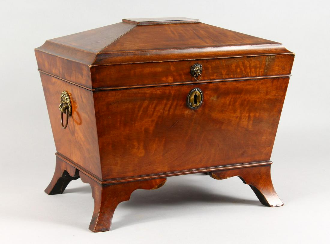 A LARGE REGENCY MAHOGANY SARCOPHAGUS-SHAPED MINIATURE: A LARGE REGENCY MAHOGANY SARCOPHAGUS-SHAPED MINIATURE CELLARETTE with lift-up lid, velvet interior, brass lion ring handle and supported on splayed bracket feet. 16ins long.