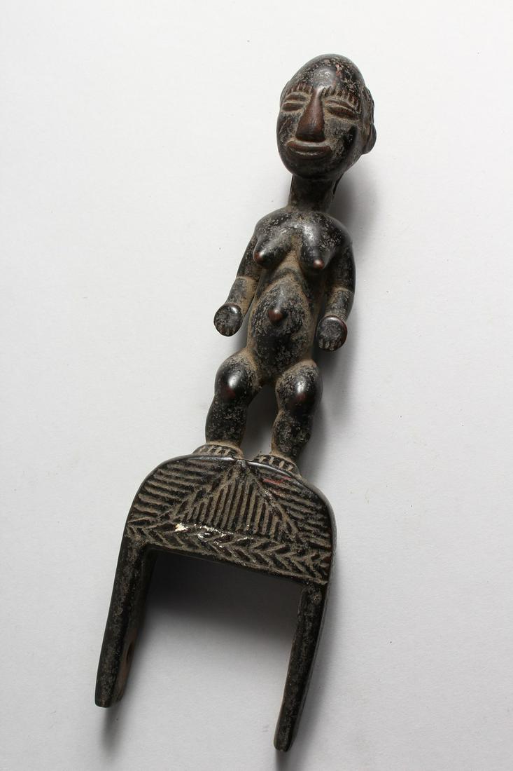 A CARVED WOOD FIGURAL TRIBAL PULLEY. 10ins high.: A CARVED WOOD FIGURAL TRIBAL PULLEY. 10ins high.
