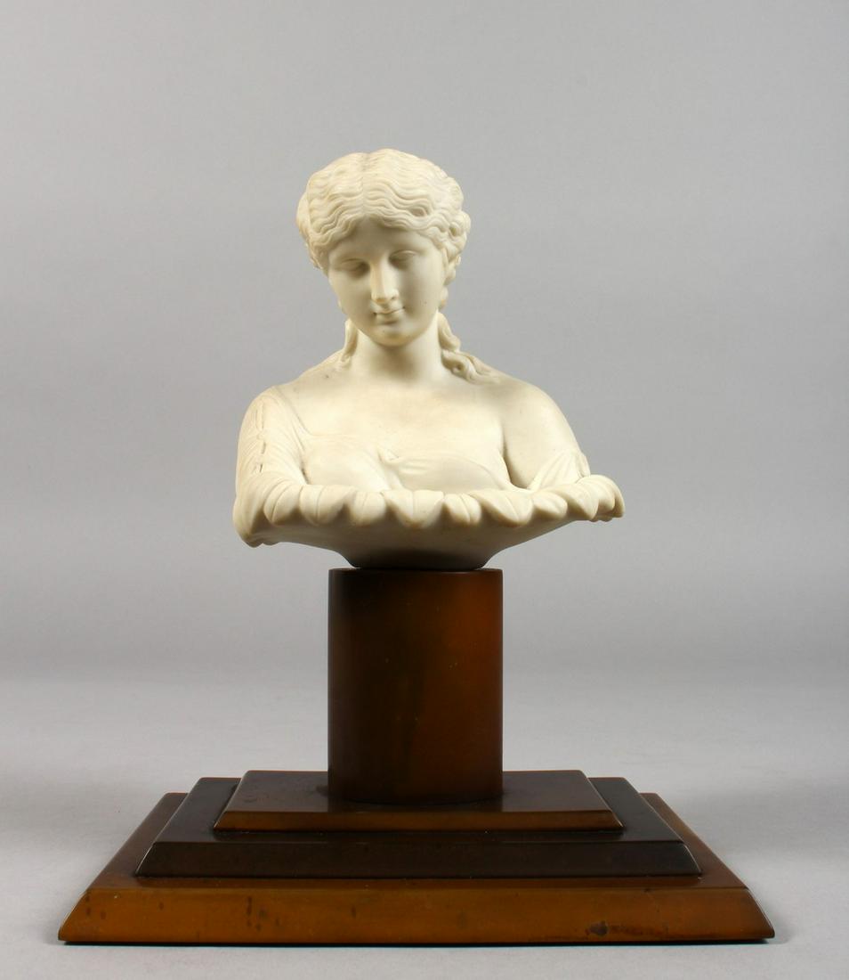 A CLASSICAL PARIAN BUST of a young lady, on a wooden: A CLASSICAL PARIAN BUST of a young lady, on a wooden base. 8.5ins high overall.