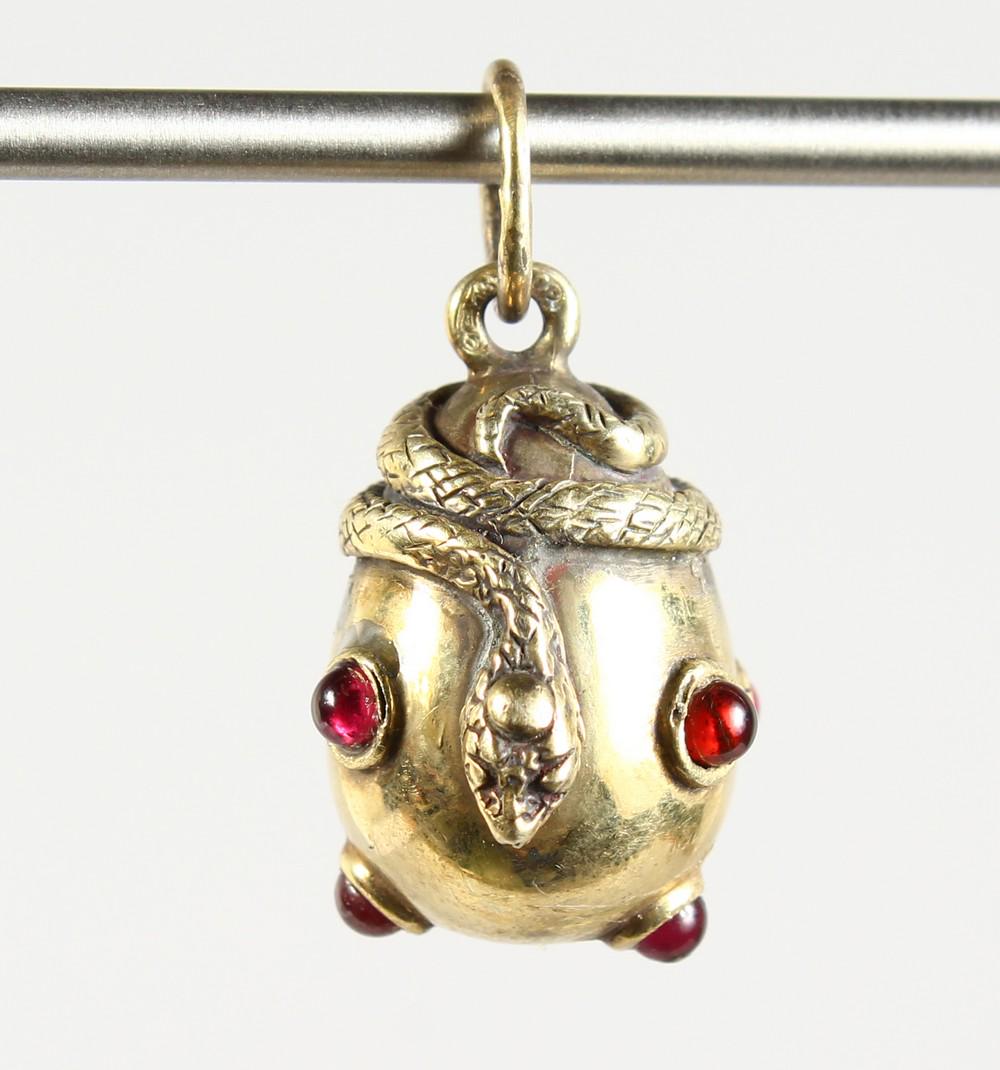 A SMALL RUSSIAN SILVER GILT AND GARNET SET SNAKE EGG: A SMALL RUSSIAN SILVER GILT AND GARNET SET SNAKE EGG PENDANT. 1ins long.