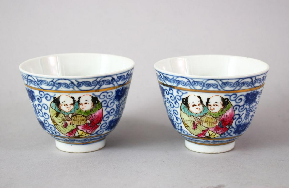 A GOOD PAIR OF CHINESE QIANLONG STYLE BLUE & WHITE AND: A GOOD PAIR OF CHINESE QIANLONG STYLE BLUE & WHITE AND FAMILLE ROSE PORCELAIN CUPS, the cups decorated with symbols with panels of figures, the bases with six character Qianlong marks. 5.5cm high x 7.