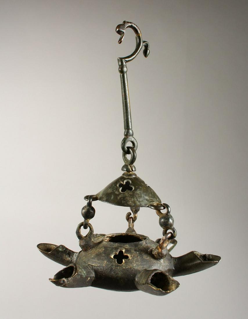 A BYZANTINE BRONZE LAMP with six nozzles and suspension: A BYZANTINE BRONZE LAMP with six nozzles and suspension chain. 7.5ins wide.