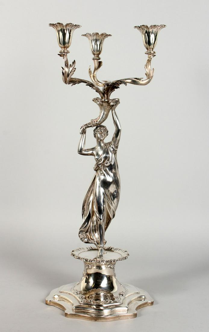 A GOOD VICTORIAN SILVER TABLE CENTRE CANDELABRA, with: A GOOD VICTORIAN SILVER TABLE CENTRE CANDELABRA, with three scrolling branches emanating from a cornucopia being held aloft by a classical female figure, on a shaped base. London 1840. Weight 65ozs. 2