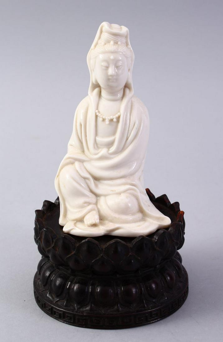 A GOOD CHINESE BLANC DE CHINE PORCELAIN FIGURE OF: A GOOD CHINESE BLANC DE CHINE PORCELAIN FIGURE OF GUANYIN ON LOTUS BASE, the figure in a meditating position, seated upon a separate carved dense hard wood lotus carved base, the figure alone is 12.5c