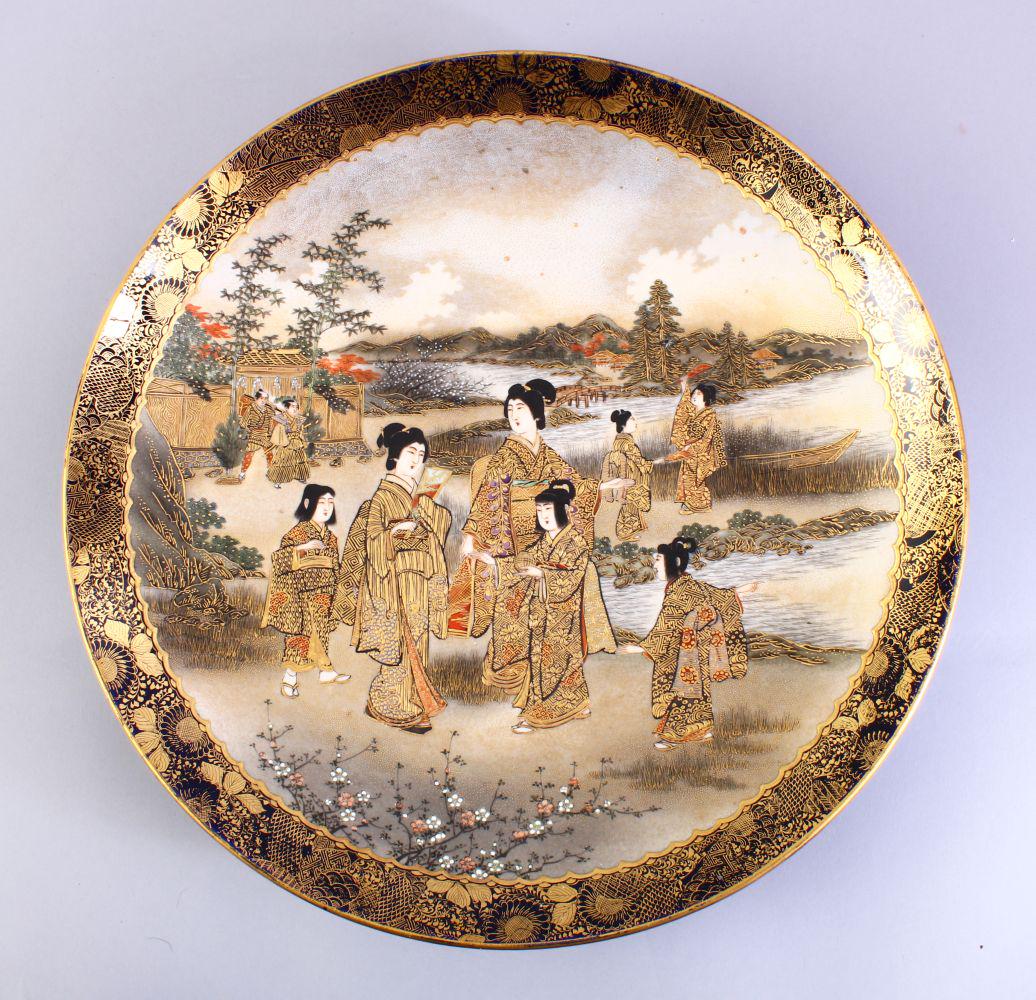 A GOOD JAPANESE MEIJI PERIOD SATSUMA PLATE, decorated: A GOOD JAPANESE MEIJI PERIOD SATSUMA PLATE, decorated with scenes of females in a landscape setting with two warriors amongst buildings, the base with a black gilt seal mark, 31.5cm diameter,