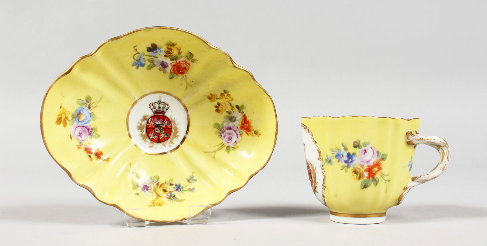 A 19TH CENTURY MEISSEN YELLOW GROUND CABARET CUP AND: A 19TH CENTURY MEISSEN YELLOW GROUND CABARET CUP AND SAUCER crested and painted with flowers. Crossed sword marks in blue.