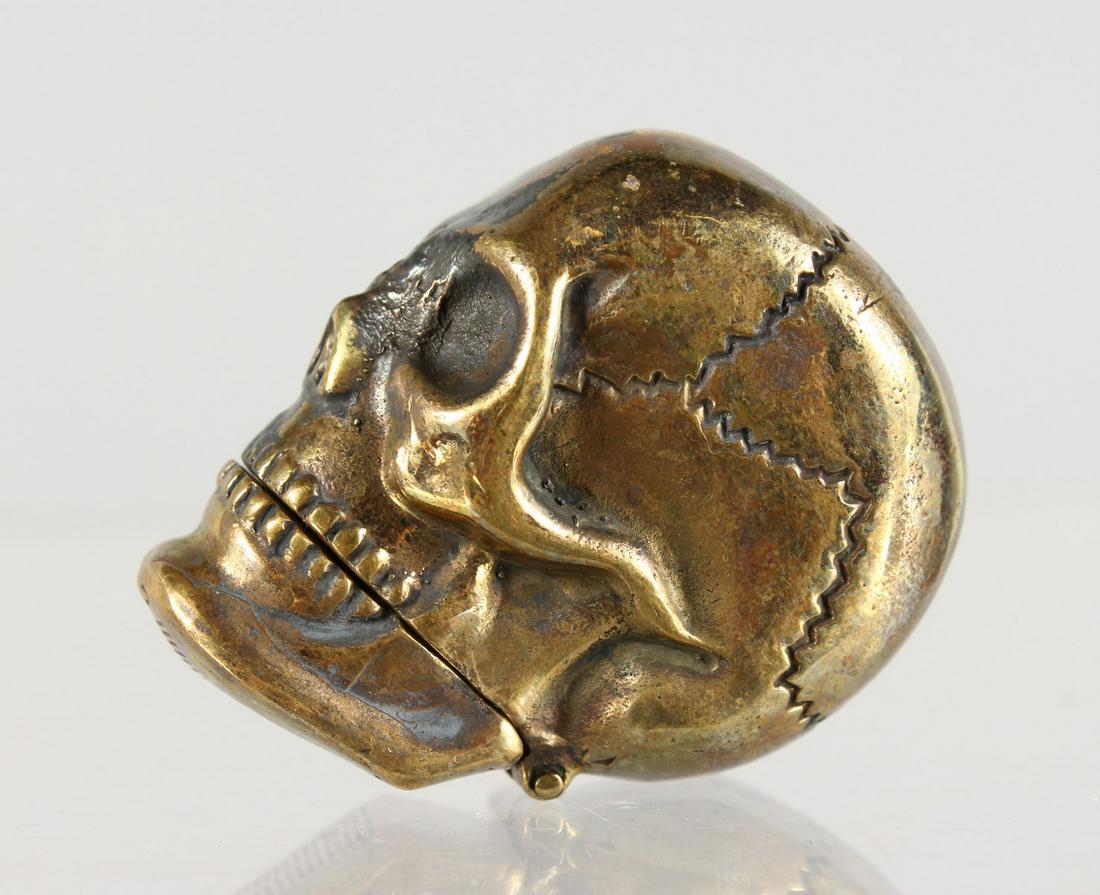 A BRASS SKULL SHAPE VESTA CASE.: A BRASS SKULL SHAPE VESTA CASE.