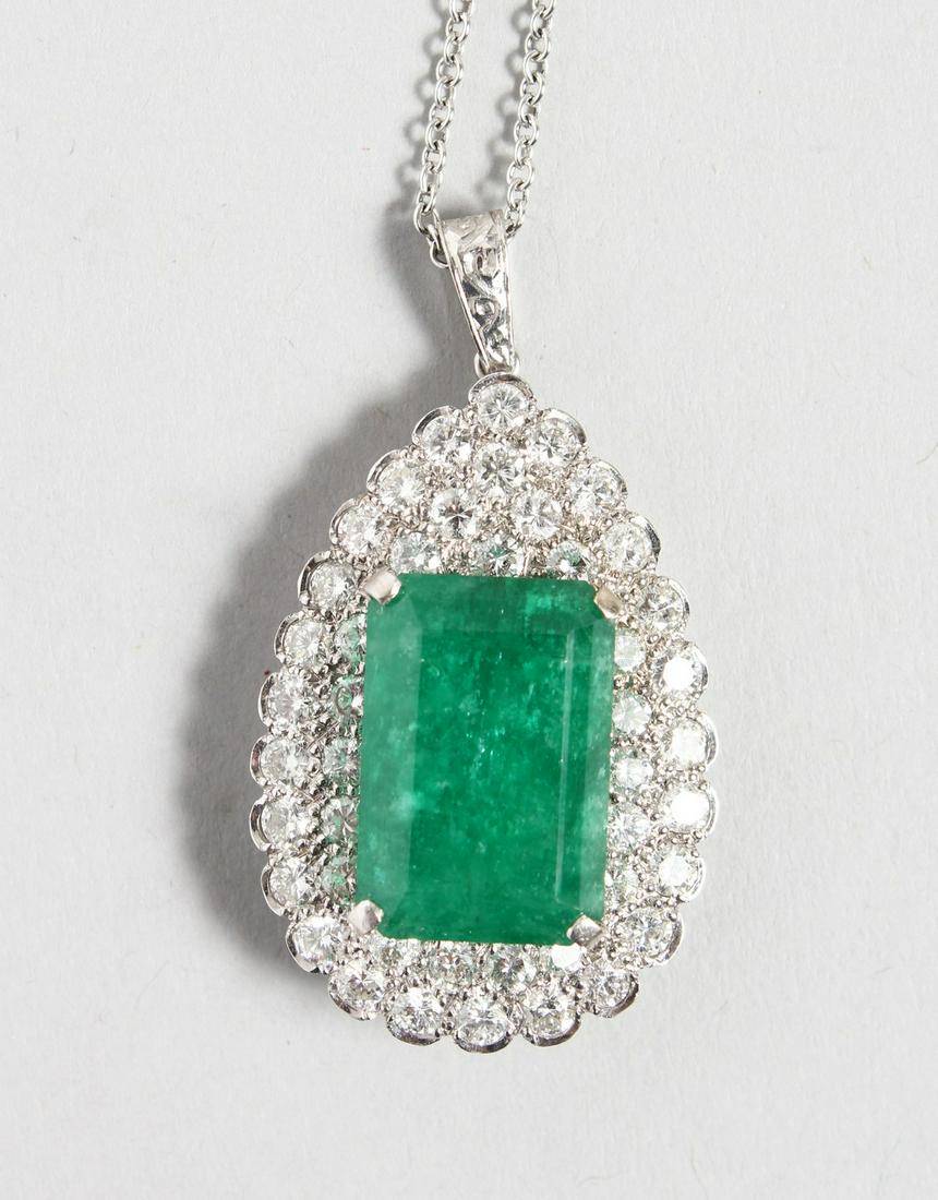 A GOOD 18CT WHITE GOLD PEAR SHAPED PENDANT inset with a: A GOOD 18CT WHITE GOLD PEAR SHAPED PENDANT inset with a central rectangular emerald, surrounded by numerous diamonds. 1.5ins high.