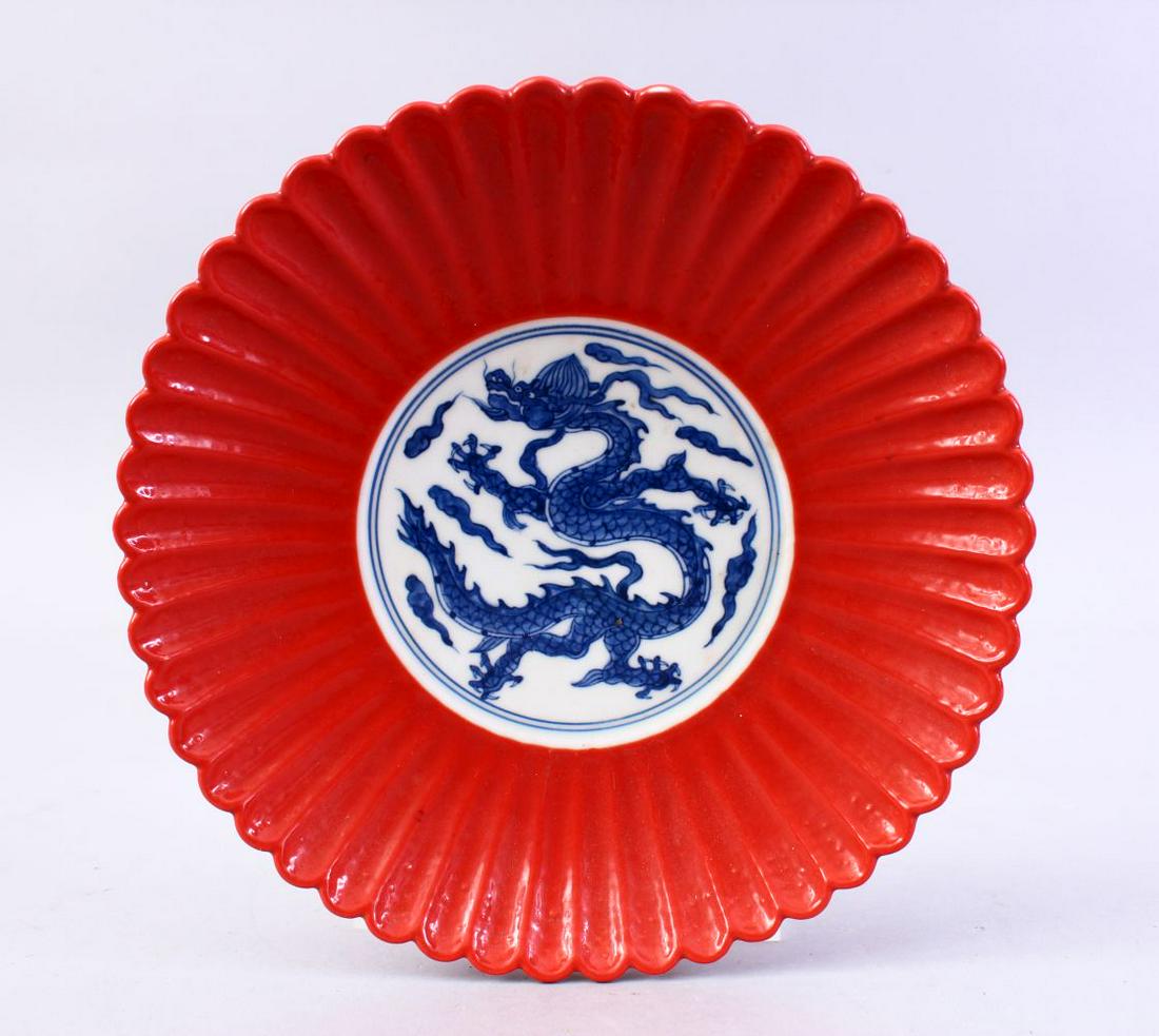 A GOOD CHINESE MING STYLE CORAL GROUND MOULDED PETAL: A GOOD CHINESE MING STYLE CORAL GROUND MOULDED PETAL PORCELAIN DISH, the dish with a blue & white decoration of a dragon, the base with a six character mark, 18cm.