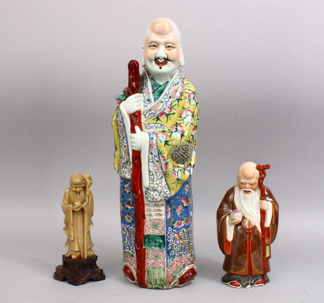 A LARGE CHINESE FAMILLE ROSE PORCELAIN FIGURE OF A MAN,: A LARGE CHINESE FAMILLE ROSE PORCELAIN FIGURE OF A MAN, the fiigure with an impressed tongzhi mark to the base, possibly period, 43cm high together with a smaller famille rose figure, and a soapstone 