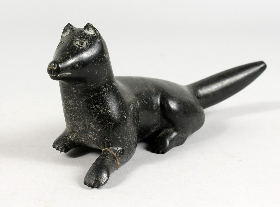 AN INUIT CARVED HARDSTONE GROUP OF A FOX LAYING DOWN.: AN INUIT CARVED HARDSTONE GROUP OF A FOX LAYING DOWN. 9ins long.