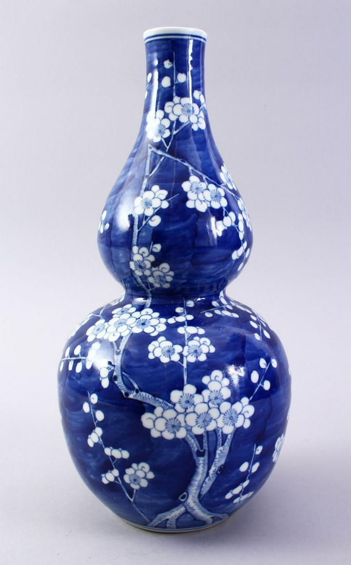 A GOOD CHINESE BLUE & WHITE DOUBLE GOURD PORCELAIN: A GOOD CHINESE BLUE & WHITE DOUBLE GOURD PORCELAIN VASE, the body of the vase decorated with blossom tree decoration, the base with a four character kangxi mark, 33cm high.