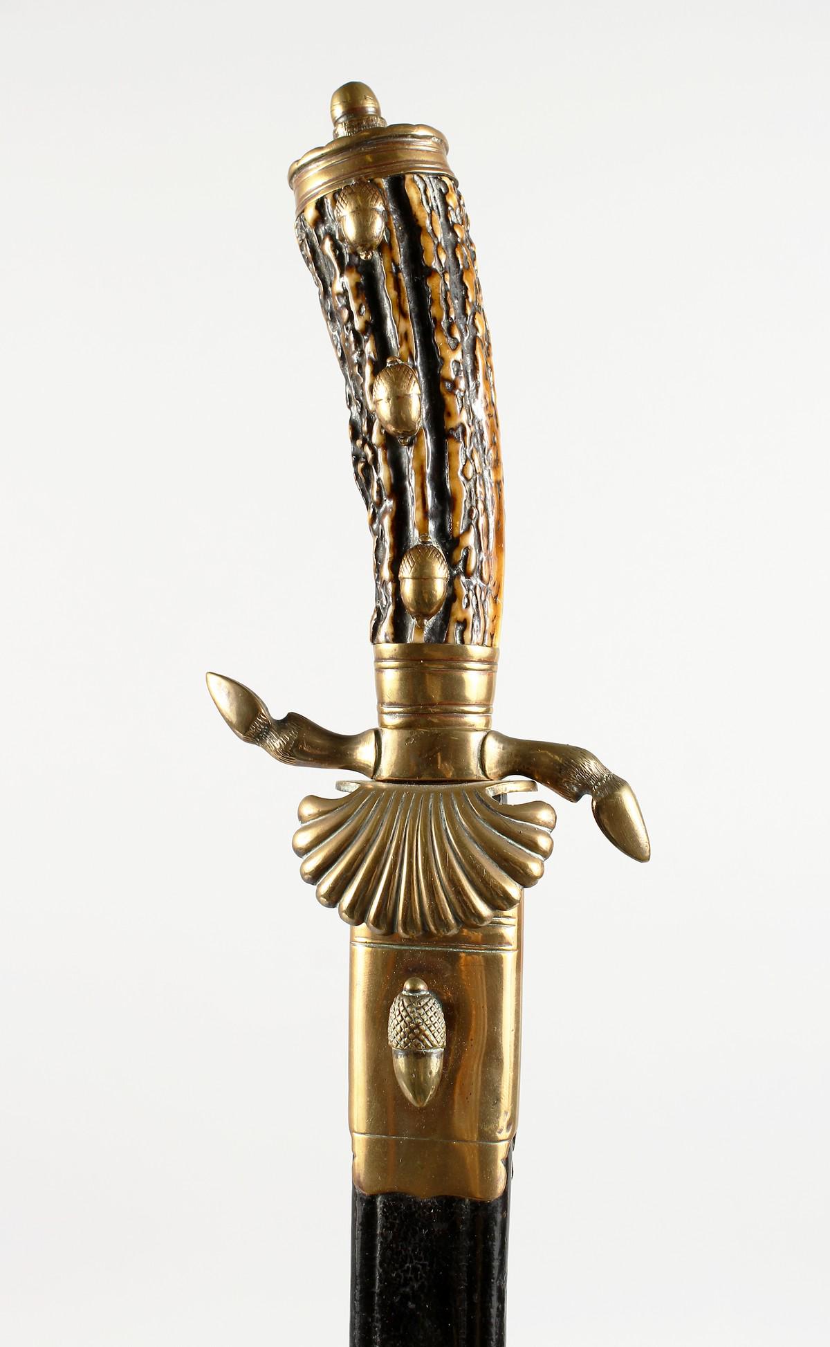 A SCOTTISH SWORD with bone and brass handle, in a: A SCOTTISH SWORD with bone and brass handle, in a leather sheath. 23ins long.