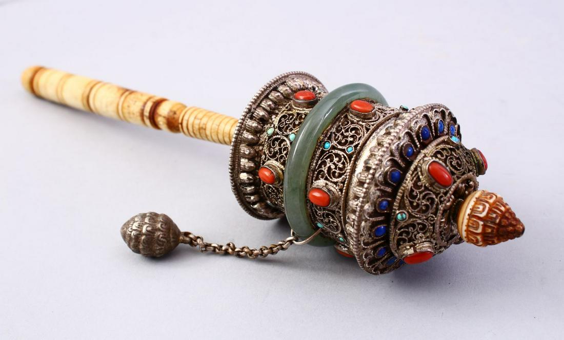 A GOOD 19TH CENTURY TIBETAN WHITE METAL AND INLAID: A GOOD 19TH CENTURY TIBETAN WHITE METAL AND INLAID PRAYER WHEEL, the wheel with filigree style metal work with inlaid turquoise and coral, with a green jade band around the centre with a bone handle, 