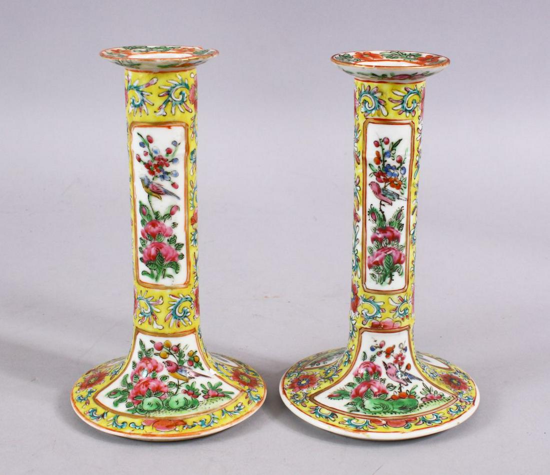 A PAIR OF 19TH CENTURY CHINESE CANTON FAMILLE JAUNE /: A PAIR OF 19TH CENTURY CHINESE CANTON FAMILLE JAUNE / ROSE CANDLESTICKS, decorated with panels of flora and birds, 17cm.