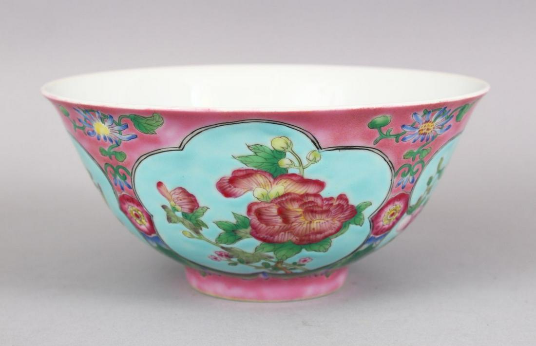 A CHINESE PINK GROUND FAMILLE ROSE PORCELAIN BOWL, with: A CHINESE PINK GROUND FAMILLE ROSE PORCELAIN BOWL, with panels of native flora on a blue ground, the base with a four character mark, 15cm dia.