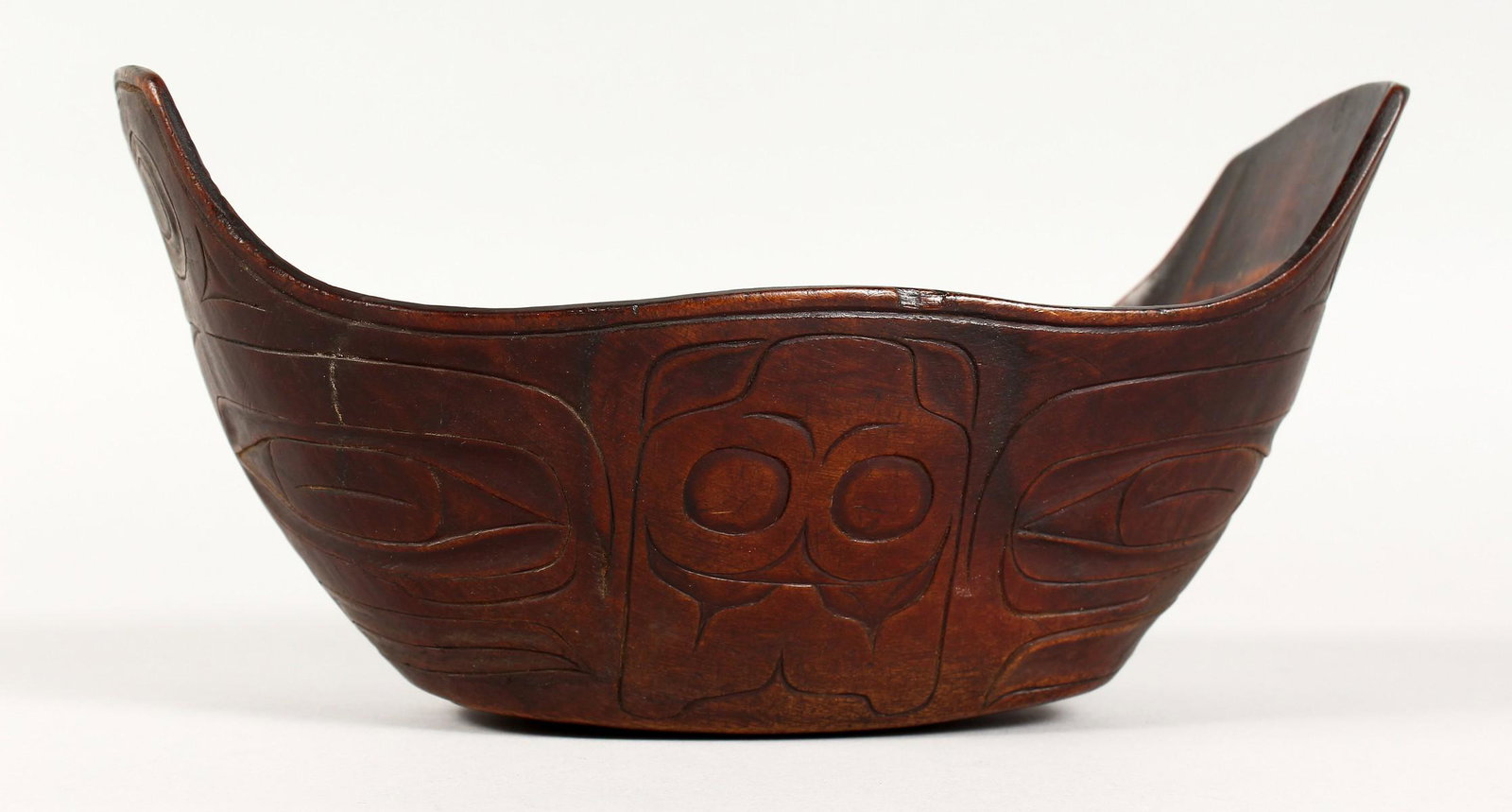 A CARVED WOOD FOOD BOWL, possibly Maori. 9ins long.: A CARVED WOOD FOOD BOWL, possibly Maori. 9ins long.