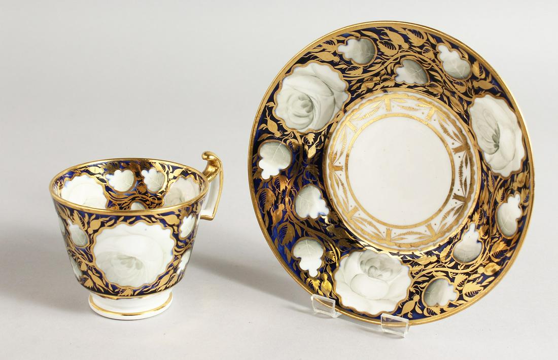 A MINTON RICH BLUE CUP AND SAUCER painted with roses.: A MINTON RICH BLUE CUP AND SAUCER painted with roses.
