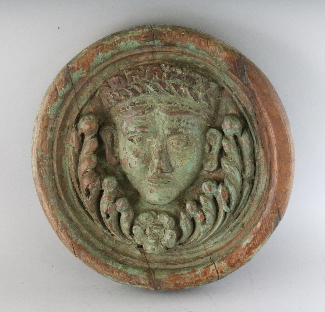 AN 18TH CENTURY CARVED WOOD ROUNDEL, carved with a: AN 18TH CENTURY CARVED WOOD ROUNDEL, carved with a head. 11.5ins diameter.