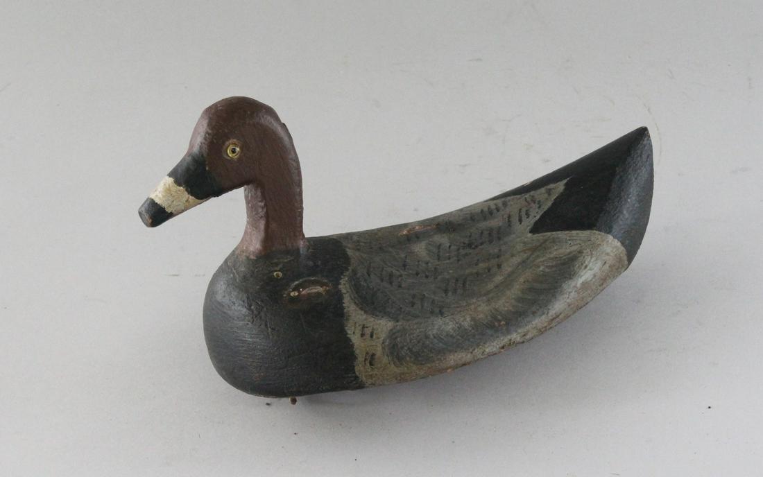A CARVED WOOD AND PAINTED DECOY DUCK. 8ins long.: A CARVED WOOD AND PAINTED DECOY DUCK. 8ins long.