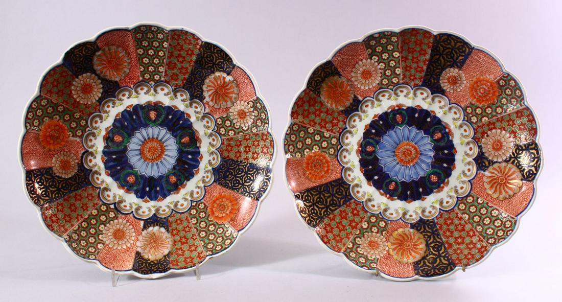 A PAIR OF JAPANESE MEIJI PERIOD IMARI PORCELAIN: A PAIR OF JAPANESE MEIJI PERIOD IMARI PORCELAIN CHRYSANTHEMUM FORMED PLATES, each decorated with floral roundel, and geometric panel borders with typical imari palate decor, 31cm.