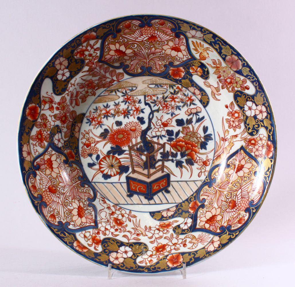 A JAPANESE EDO / MEIJI PERIOD IMARI PORCELAIN CHARGER,: A JAPANESE EDO / MEIJI PERIOD IMARI PORCELAIN CHARGER, decorated with scenes of ikebana displays with surrounding decoration with panels of birds and flora, with typical imari palate decor, (AF) 36CM.
