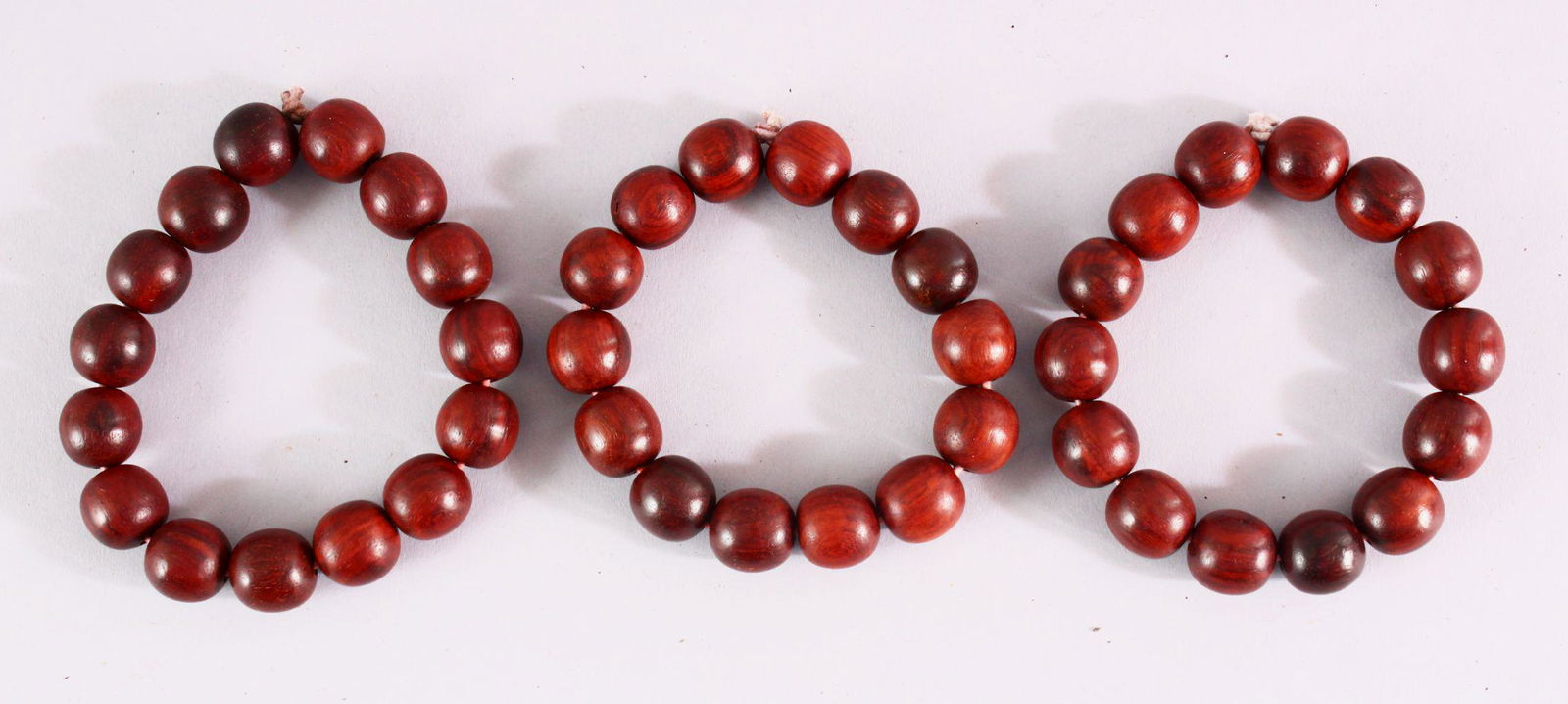 THREE RED SANDLEWOOD BEAD BRACELETS and various loose: THREE RED SANDLEWOOD BEAD BRACELETS and various loose beads.