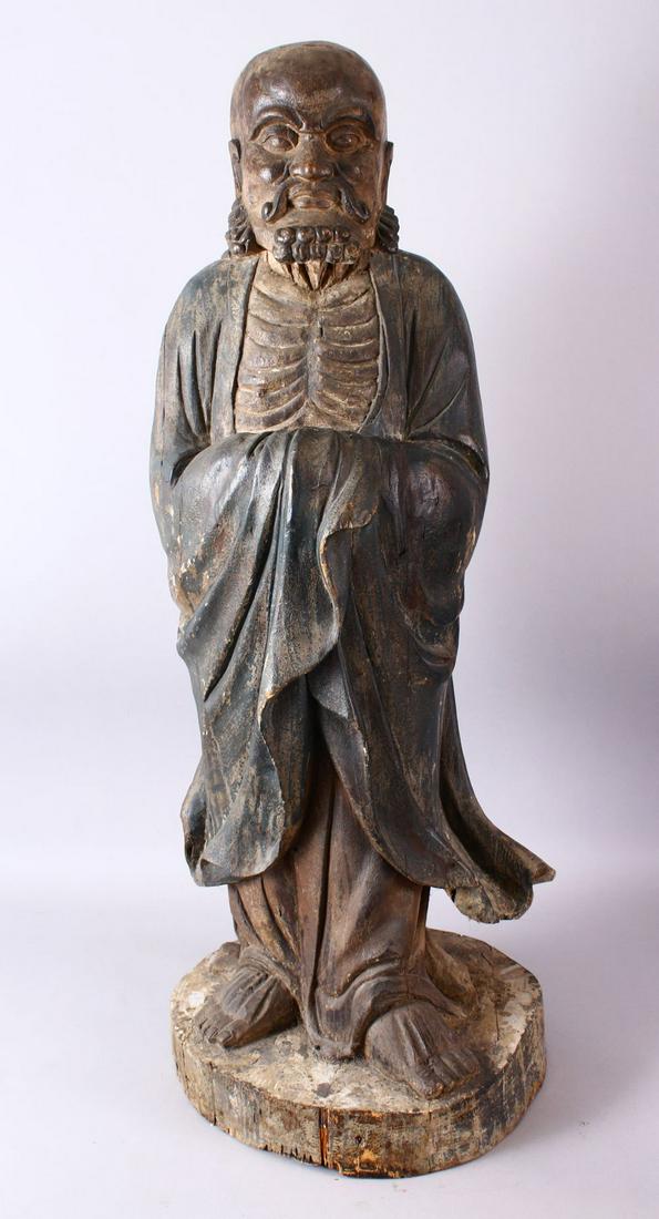 A 18TH/19TH CENTURY CHINESE CARVED WOOD FIGURE OF: A 18TH/19TH CENTURY CHINESE CARVED WOOD FIGURE OF ROHAN, on a shaped base, 90cm high.