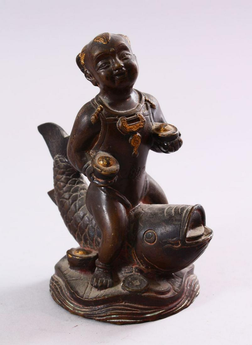 A SMALL CHINESE BRONZE FIGURE OF A BOY SEATED UPON A (1 of 6)