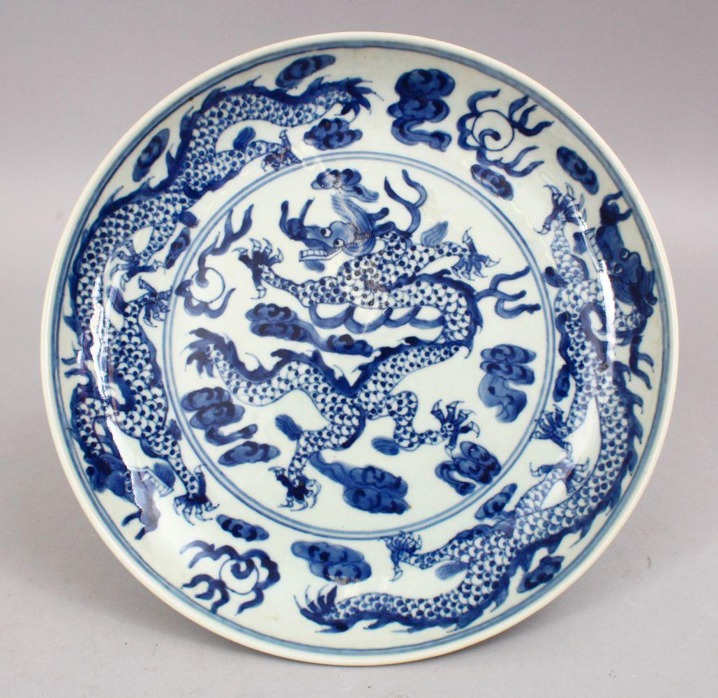 A 19TH / 20TH CENTURY CHINESE BLUE & WHITE PORCELAIN: A 19TH / 20TH CENTURY CHINESE BLUE & WHITE PORCELAIN DRAGON DISH, with three five claw dragons, the verso with six character wanli mark, 27cm.