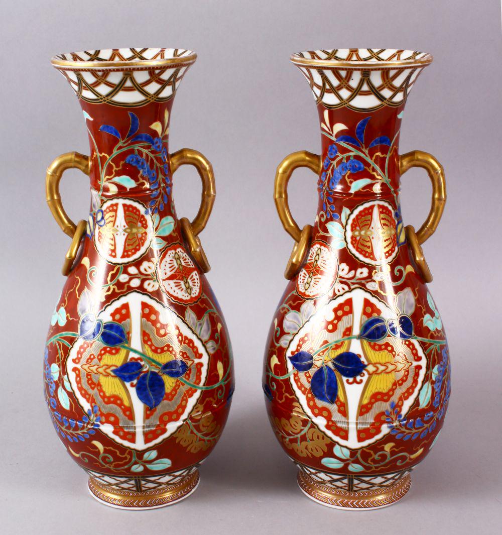 A PAIR OF JAPANESE KUTANI TWIN HANDLE VASES, with: A PAIR OF JAPANESE KUTANI TWIN HANDLE VASES, with geometric and floral decoration, with twin bamboo handle handles and rings, the bases marked, 30cm