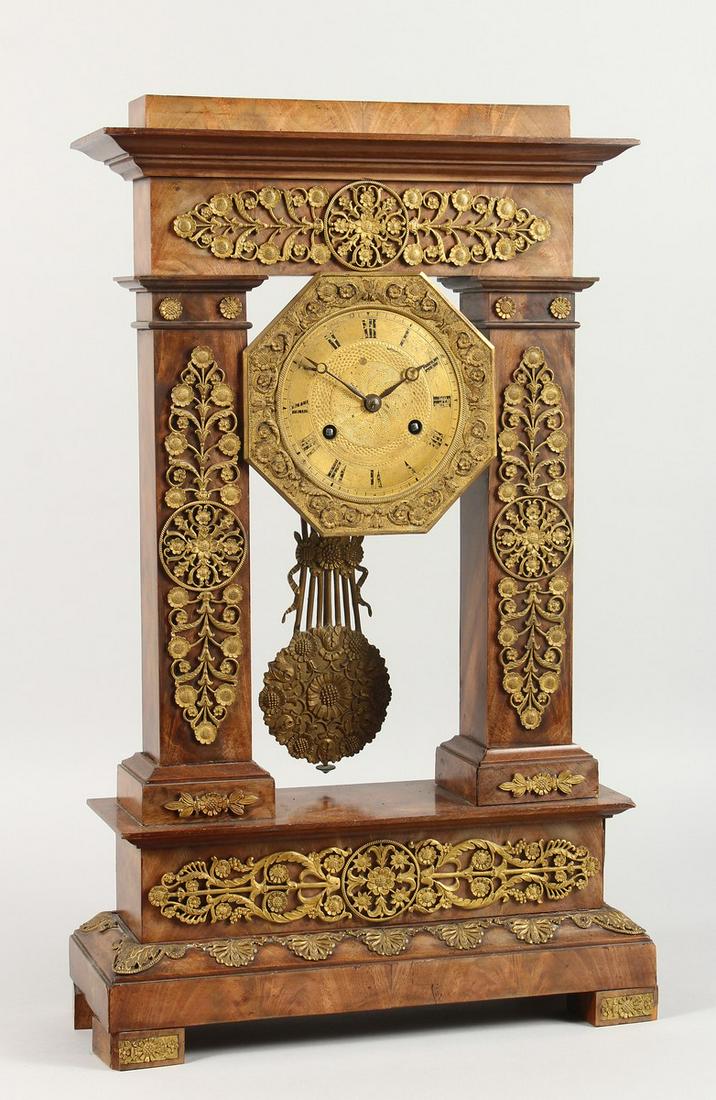 A GOOD 19TH CENTURY FRENCH EMPIRE WALNUT AND ORMOLU: A GOOD 19TH CENTURY FRENCH EMPIRE WALNUT AND ORMOLU PILLAR CLOCK with swing pendulum. 20ins high.