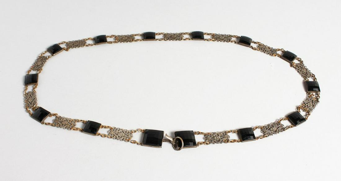 A LONG ISLAMIC FILIGREE AND CUT STONE NECKLACE, 34: A LONG ISLAMIC FILIGREE AND CUT STONE NECKLACE, 34 inches long.