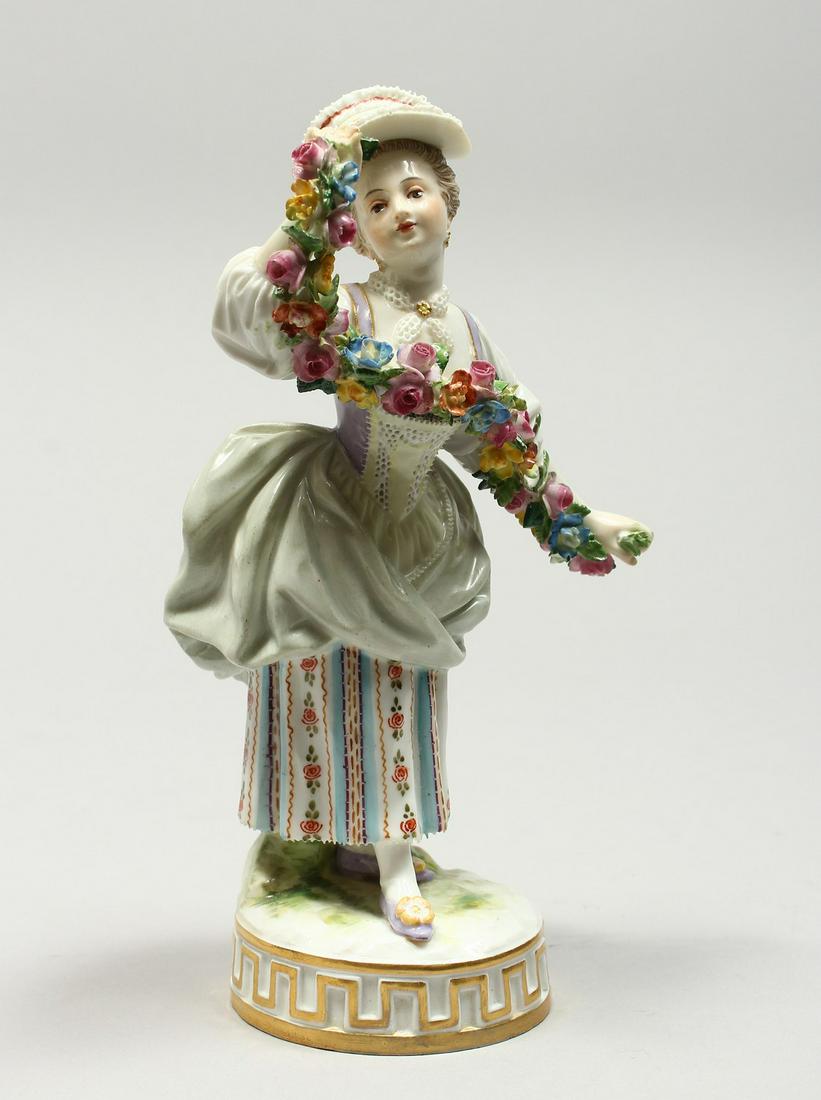 A GOOD MEISSEN PORCELAIN FIGURE OF A GIRL holding a: A GOOD MEISSEN PORCELAIN FIGURE OF A GIRL holding a garland of flowers, on a circular base. Cross swords mark in blue, incised F67. 6.75ins high.