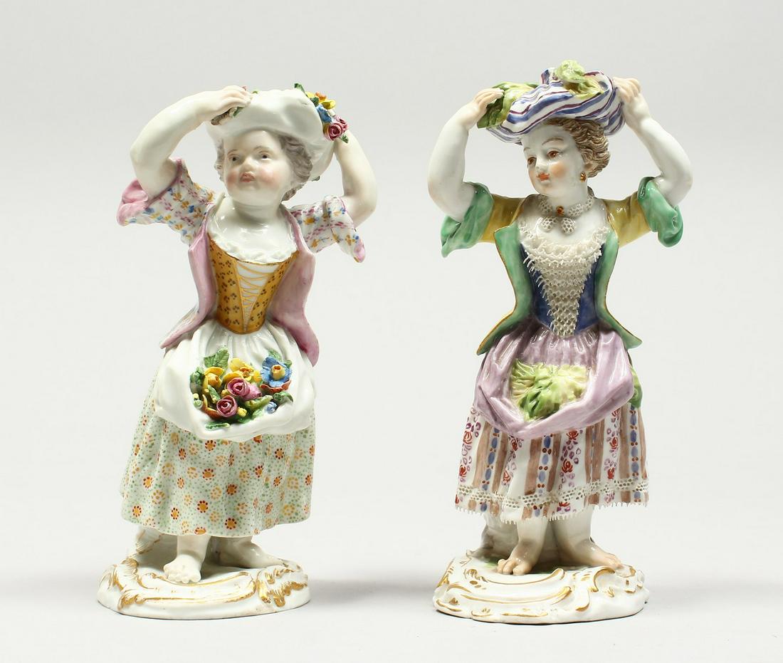 TWO SMALL MEISSEN PORCELAIN FIGURES OF YOUNG GIRLS: TWO SMALL MEISSEN PORCELAIN FIGURES OF YOUNG GIRLS holding a bundle above their head , with flowers in their aprons. Cross swords mark in blue, incised No.3. 5.25ins high