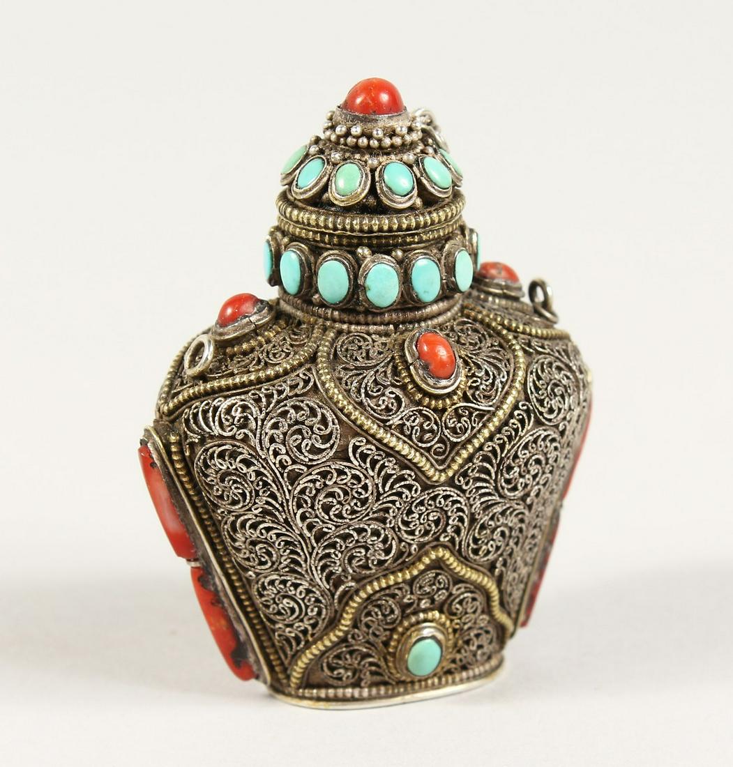 AN ISLAMIC FILIGREE SILVER SCENT BOTTLE with coral and: AN ISLAMIC FILIGREE SILVER SCENT BOTTLE with coral and turquoise stones. 2.5ins