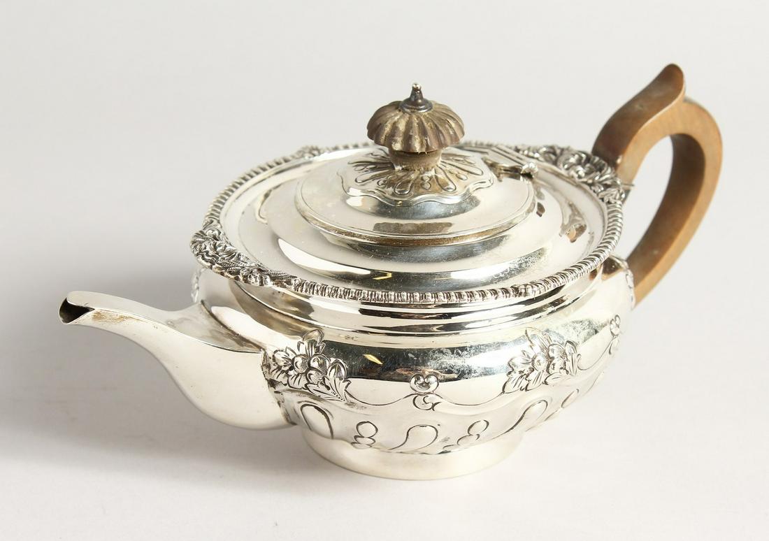 A VICTORIAN CIRCULAR SILVER TEA POT with gadrooned edge: A VICTORIAN CIRCULAR SILVER TEA POT with gadrooned edge and repousse decoration. London 1896, maker Charles Stuart Harris. Weighs 13ozs.