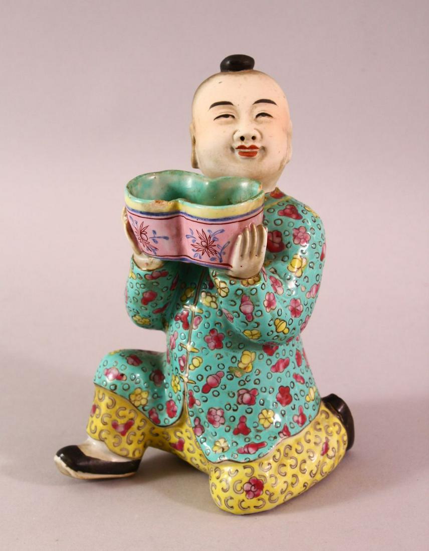 A CHINESE FAMILLE ROSE TURQUOISE GROUND PORCELAIN: A CHINESE FAMILLE ROSE TURQUOISE GROUND PORCELAIN FIGURE OF A BOY, the boy knelt holding a basket, the base ink signed, 16cm