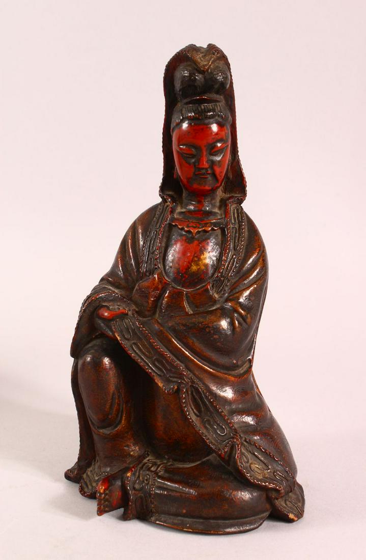 A CHINESE LACQUERED WOOD FIGURE OF GUANYIN, in a seated: A CHINESE LACQUERED WOOD FIGURE OF GUANYIN, in a seated pose, 25.5cm