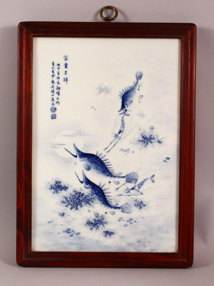 A CHINESE REPUBLIC STYLE BLUE & WHITE FISH PANEL,: A CHINESE REPUBLIC STYLE BLUE & WHITE FISH PANEL, decorated with fish, crayfish and reed, upper left with calligraphy, with a wooden frame, 39cm x 29cm