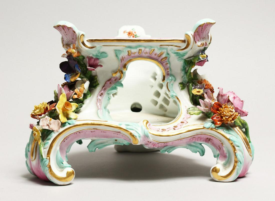A 19TH CENTURY MEISSEN PORCELAIN STAND with painted: A 19TH CENTURY MEISSEN PORCELAIN STAND with painted decoration and encrusted with flowers. Cross swords mark in blue, incised No. 2817. 5ins high.