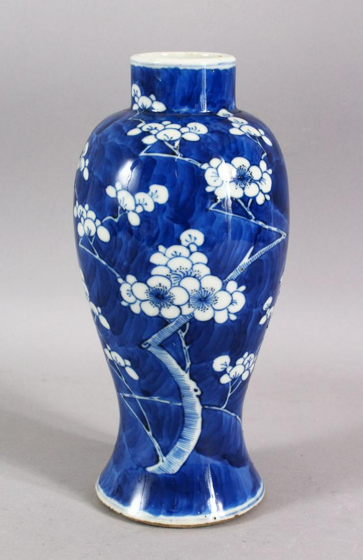 A 19TH CENTURY CHINESE BLUE & WHITE PORCELAIN PRUNUS: A 19TH CENTURY CHINESE BLUE & WHITE PORCELAIN PRUNUS VASE - decorated with a blue ground and with prunus decoration - the base with a four character Kangxi mark - 25cm high